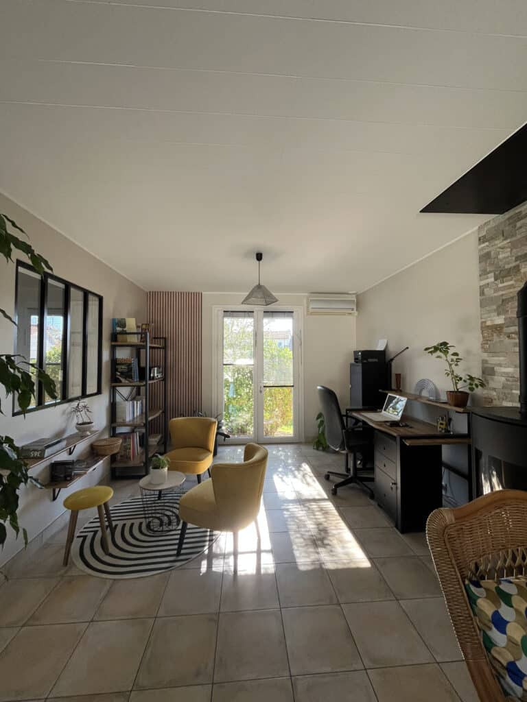 Espace d’attente aménagé à Saint-Christophe-du-Bois par ABL Intérieur avec fauteuils confortables, étagères murales, bureau en bois et métal noir, ambiance moderne et accueillante.