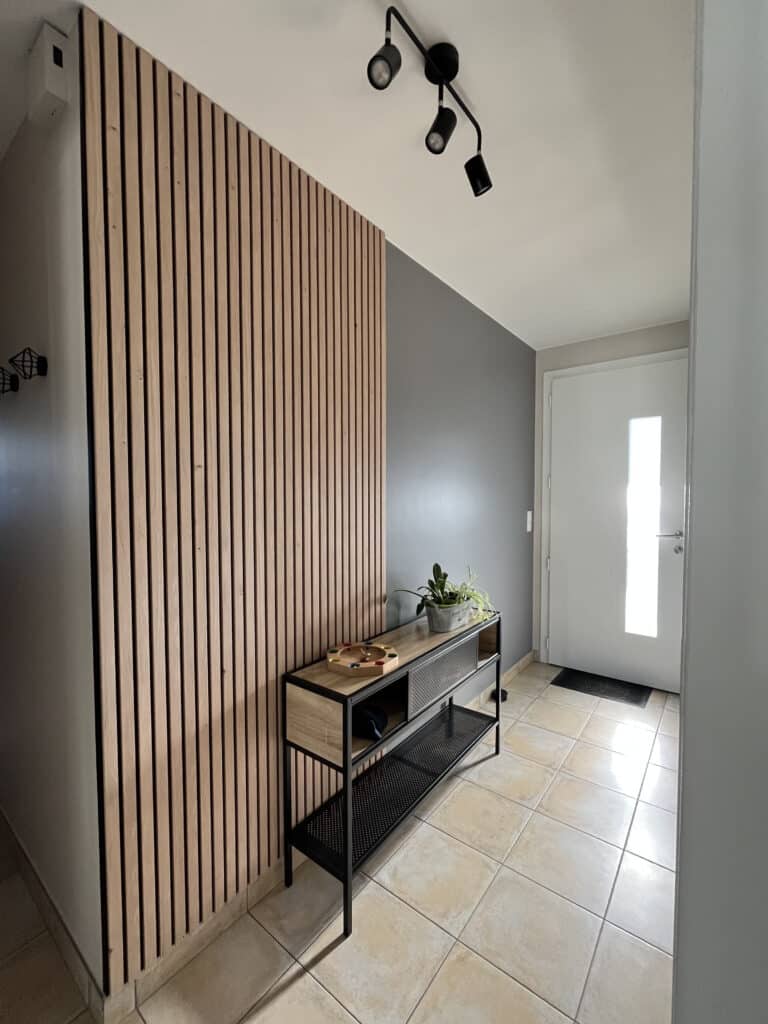 Aménagement d’entrée dans une maison à Saint-Christophe-du-Bois par ABL Intérieur avec mur en tasseaux bois, meuble console et décoration moderne
